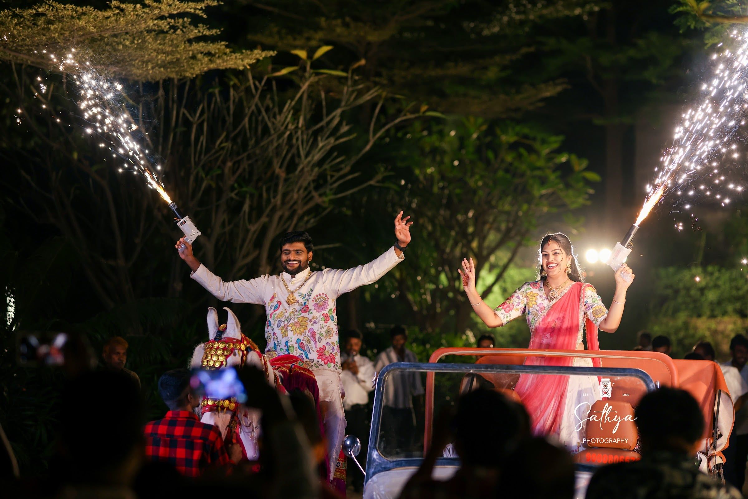 Couple arriving in an open jeep between cold-pyro sparklers