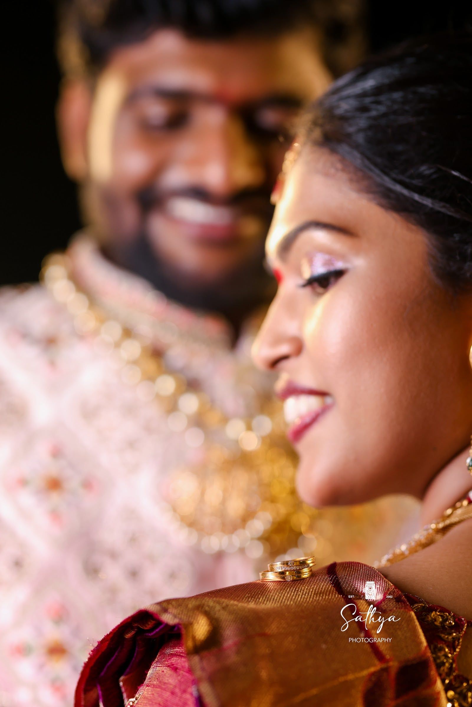 Close portrait of a laughing bride in temple jewellery with her groom