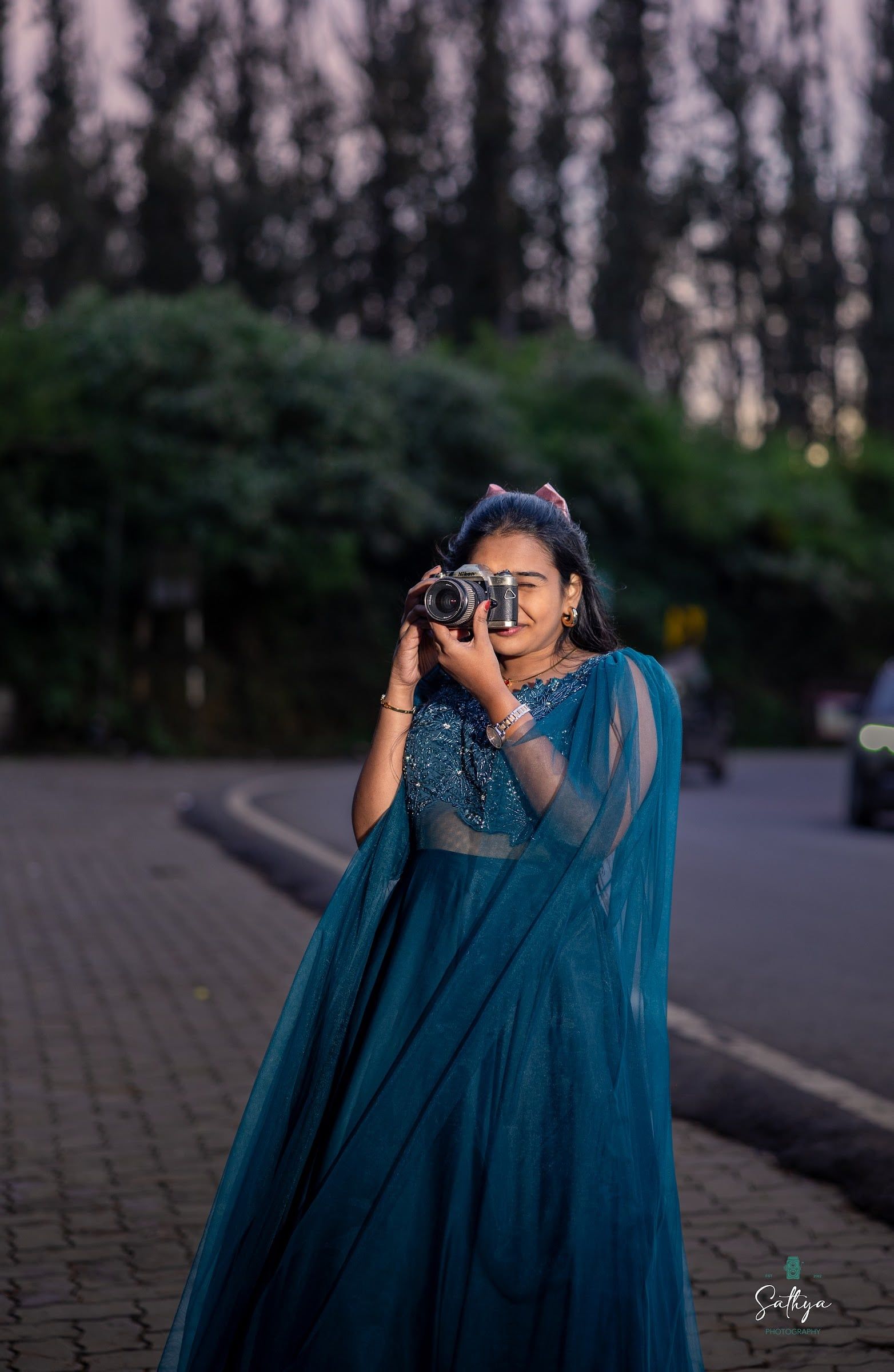 Bride in a teal lehenga playfully holding a camera