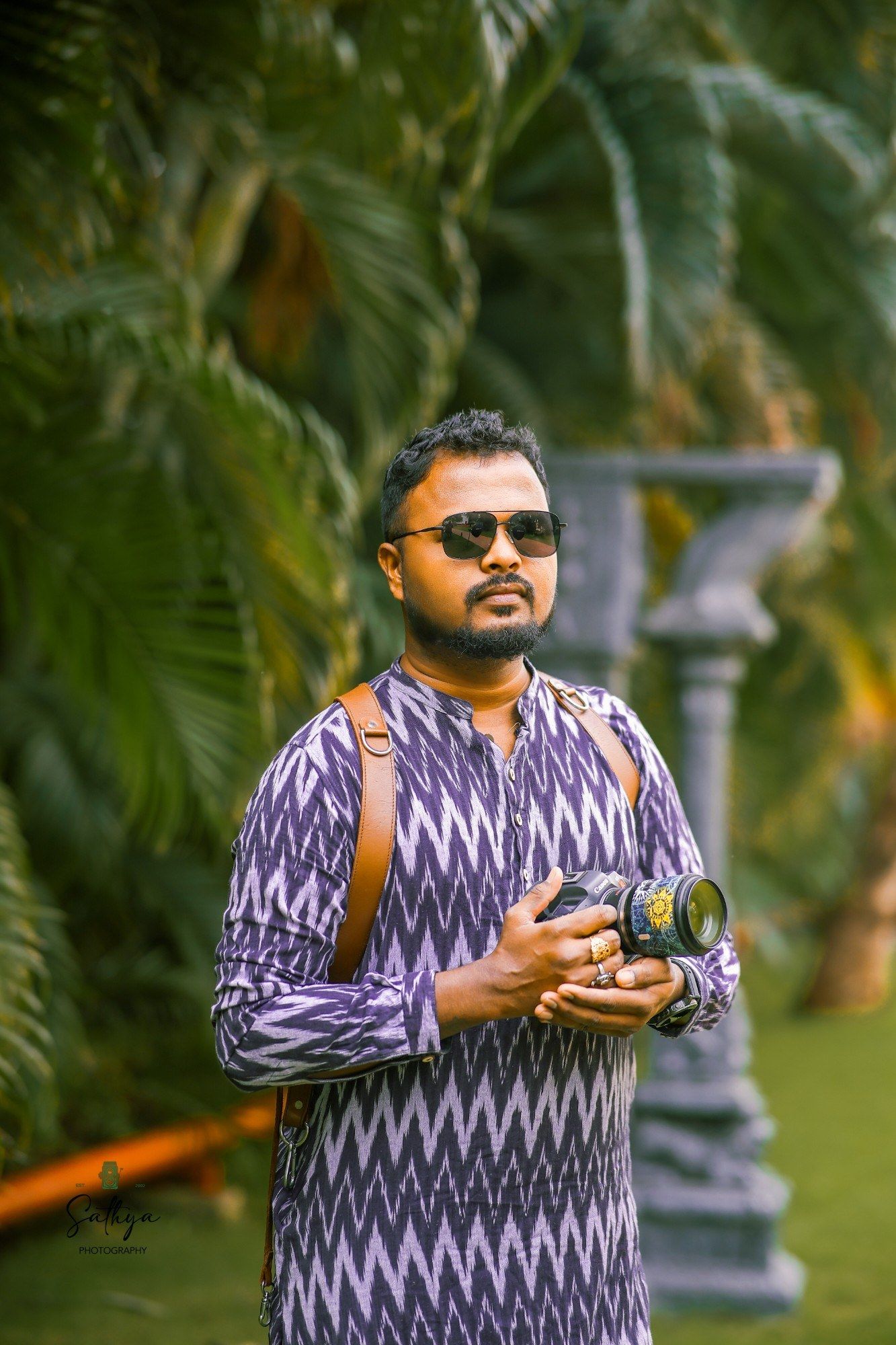 Sathya, founder of Sathya Photography, holding his camera