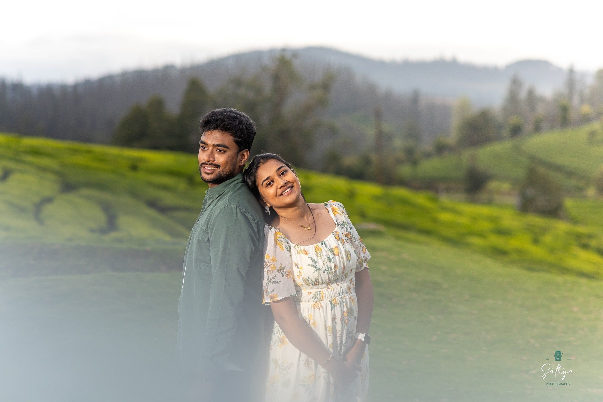 Couple portrait in drifting mist over green hills