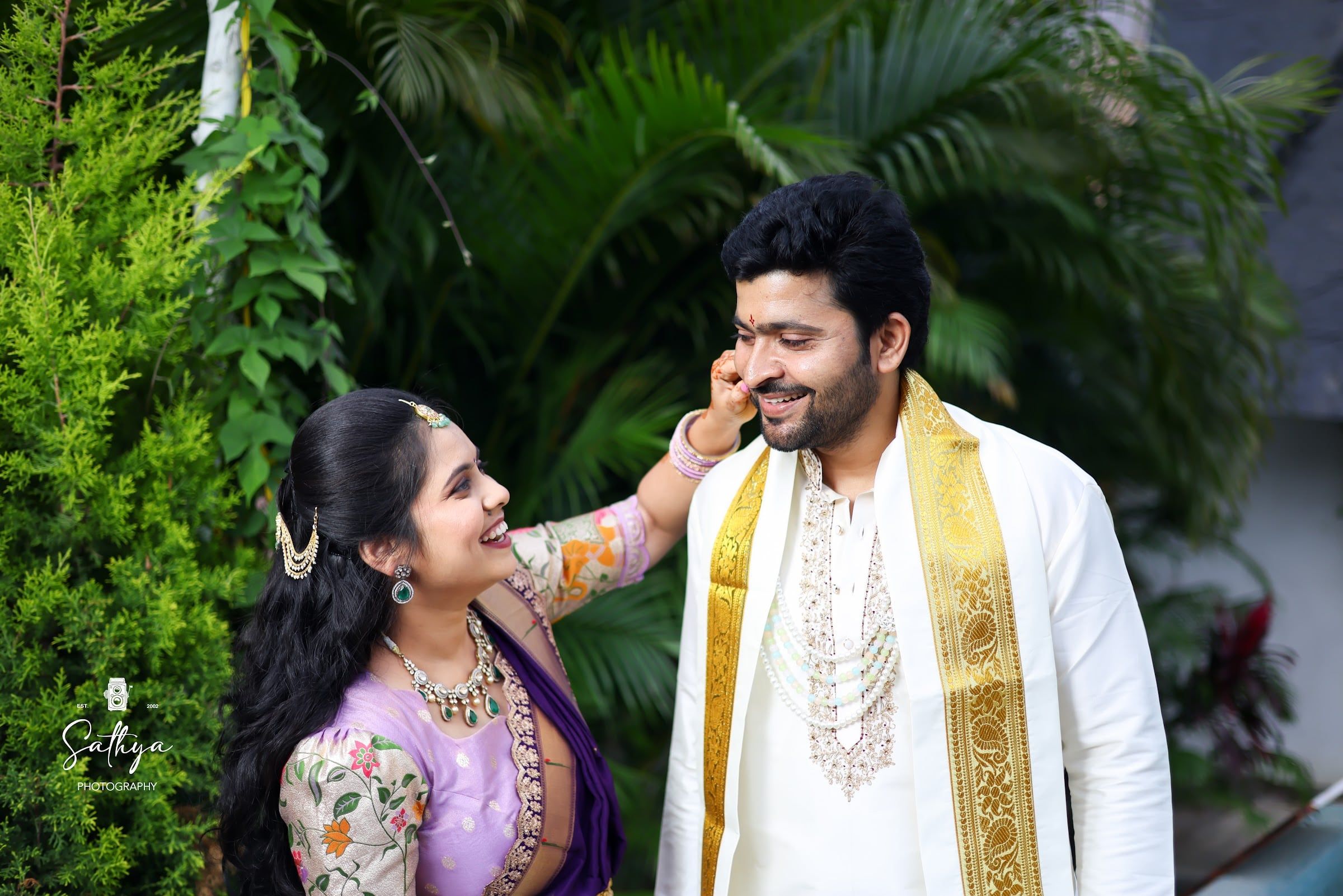 Bride playfully pinching the groom’s cheek
