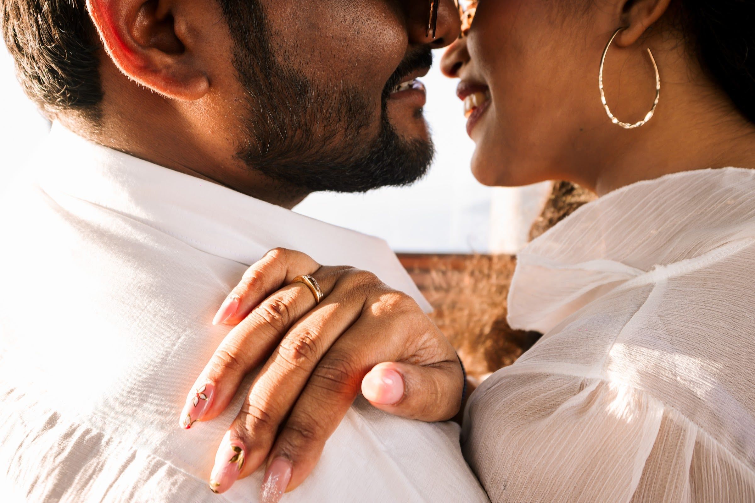 Close-up of an engagement ring as the couple embraces