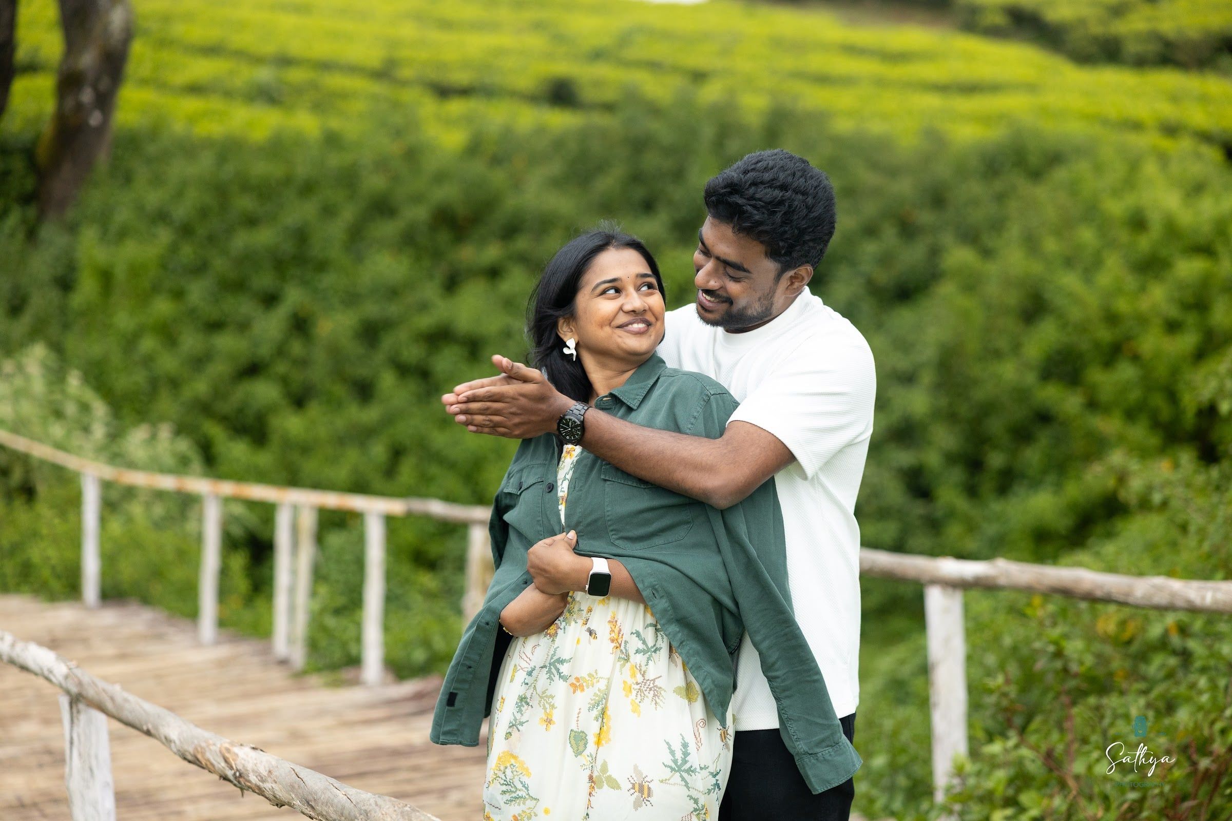 Pre-weddings & couple shoots — Couple hugging on a wooden walkway through a tea garden