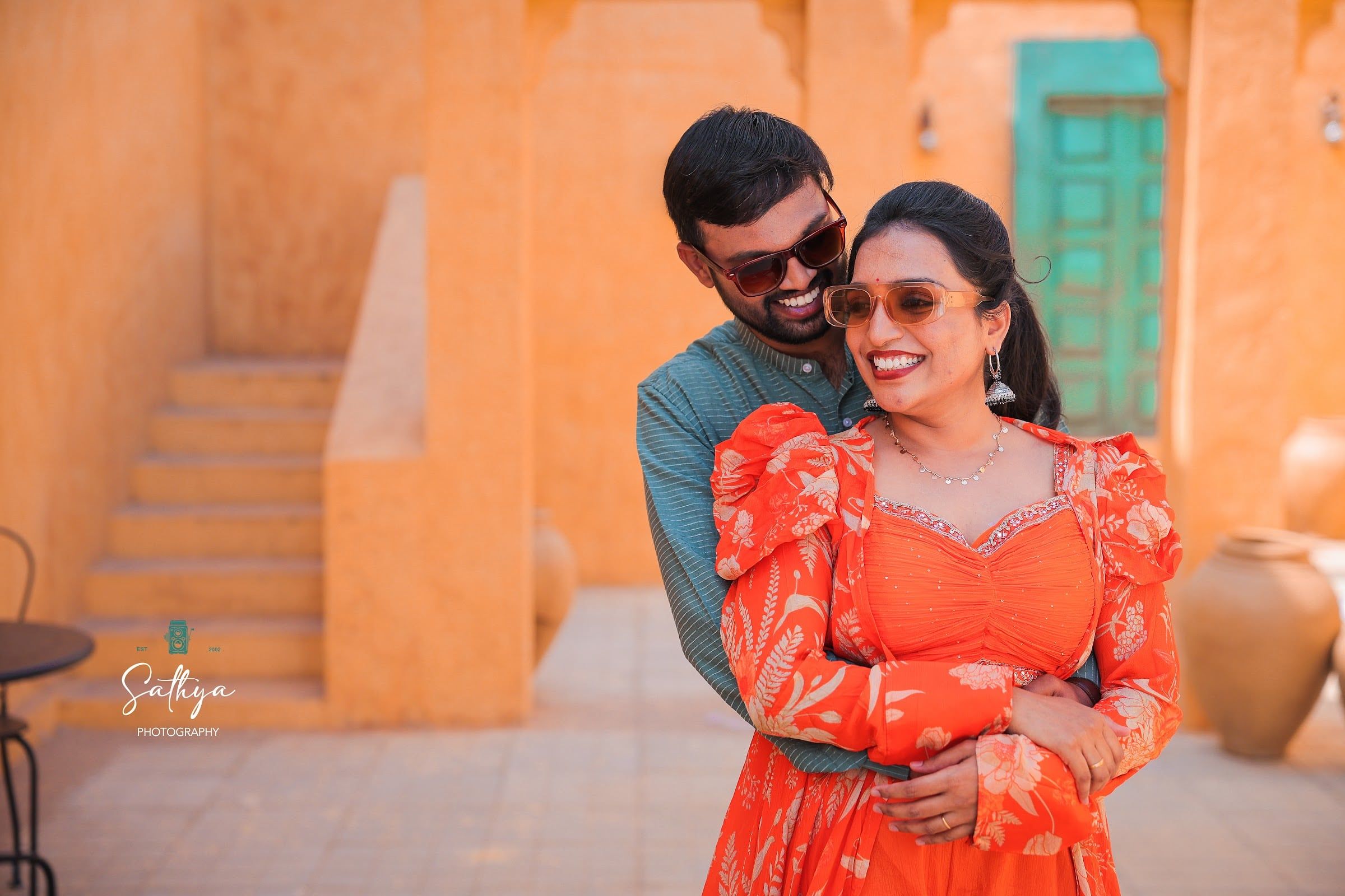 Couple laughing in a terracotta courtyard in warm light