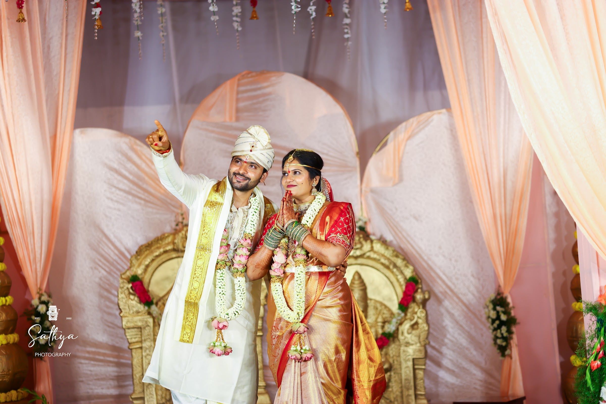 Bride and groom in garlands on the reception stage