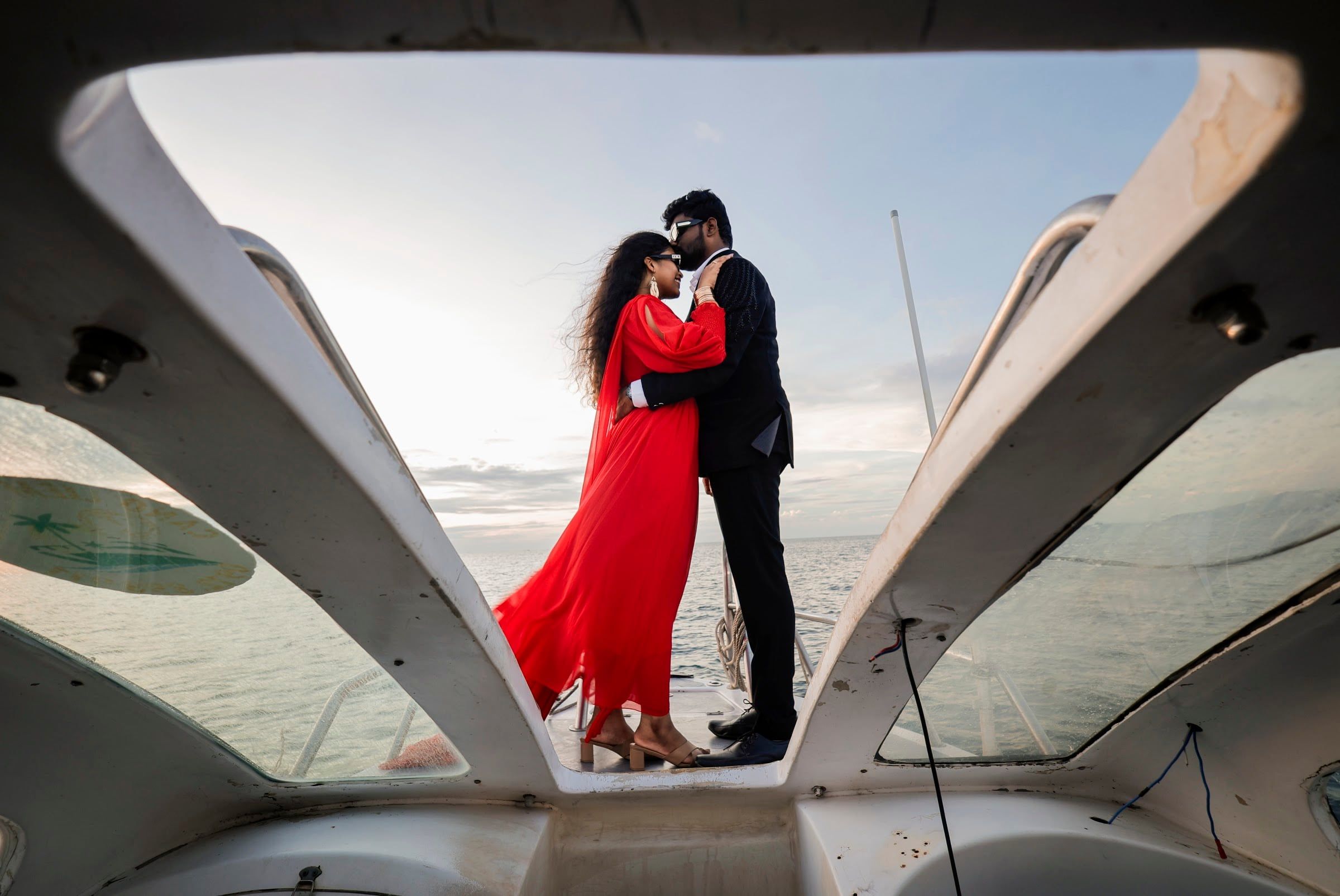 Couple embracing on the bow of a yacht at sea